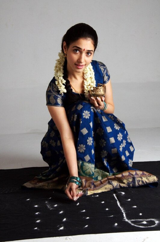 woman in sari drawing rangoli