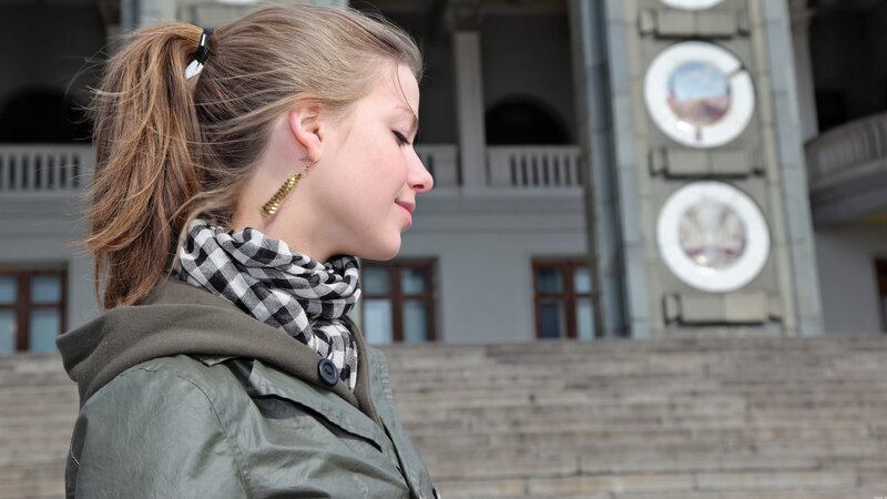 woman in scarf near building