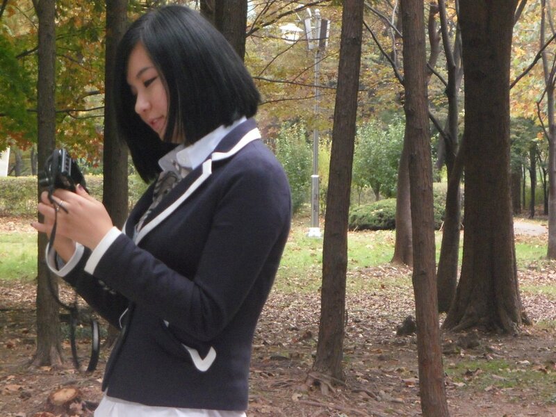 woman in school uniform holding camera