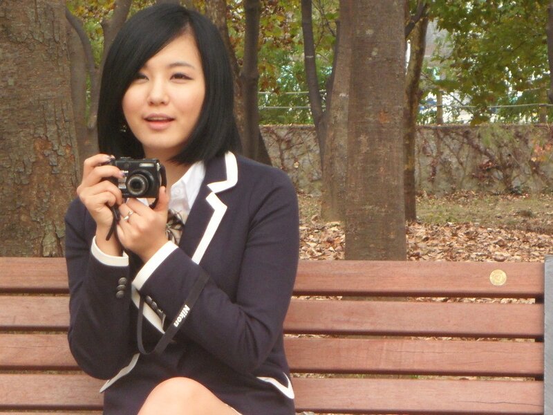 woman in school uniform holding camera