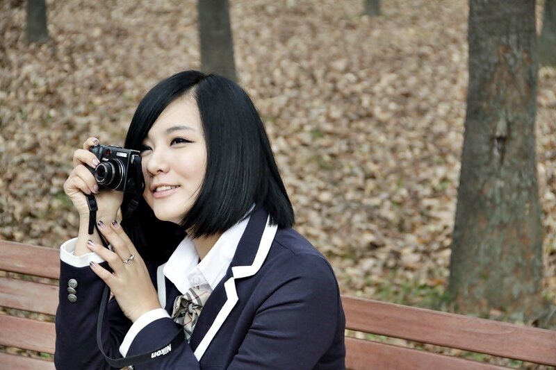 woman in school uniform holding camera