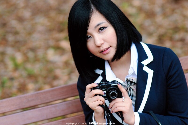 woman in school uniform holding camera