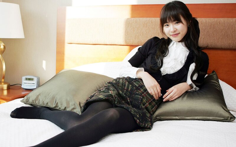 woman in school uniform on bed