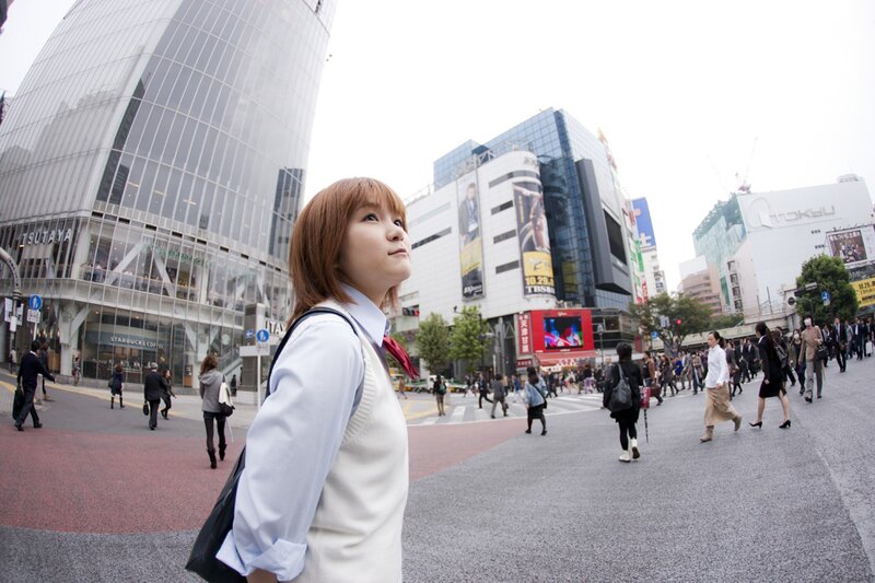 Woman in school uniform on city street