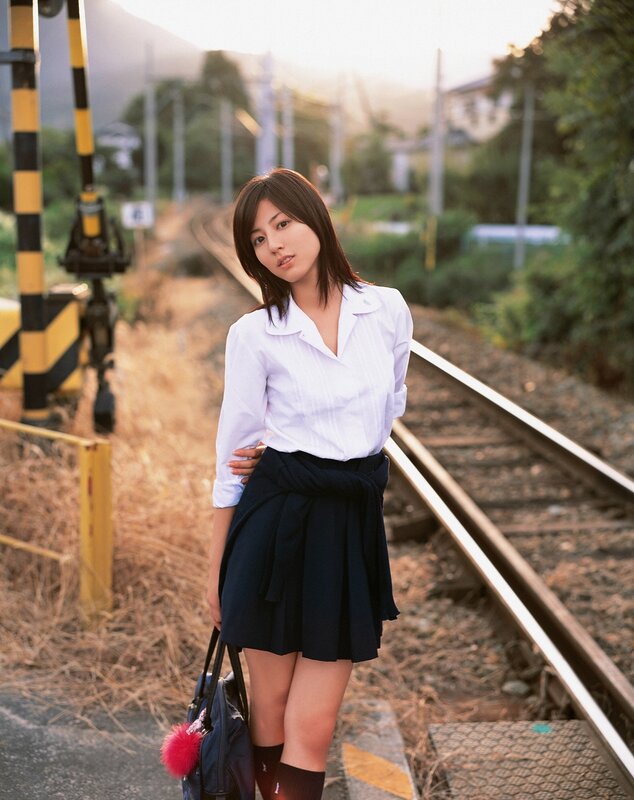 Woman in school uniform on train tracks