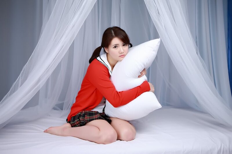 woman in school uniform with pillow