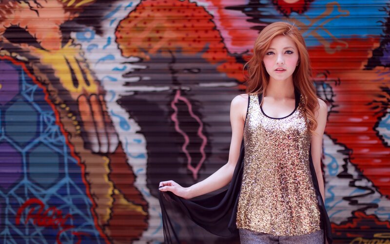 woman in sequin top against graffiti