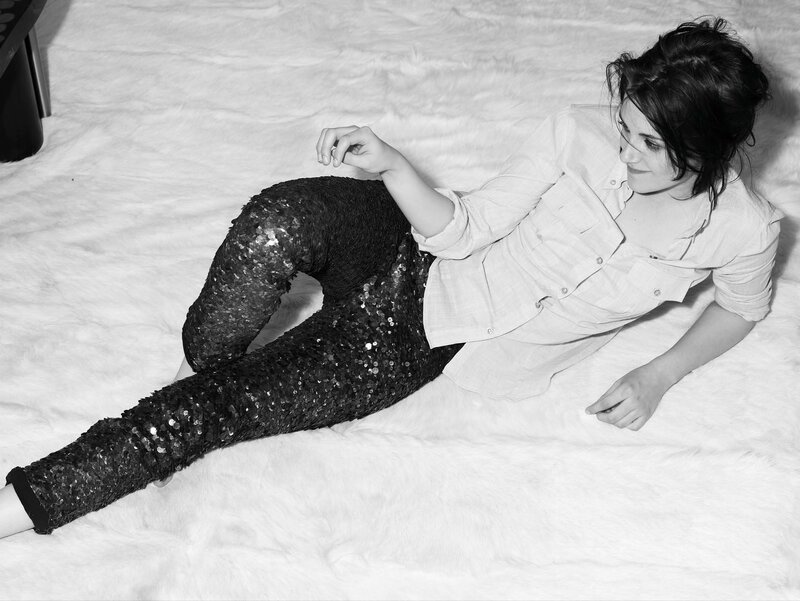 Woman in sequined pants lying on floor