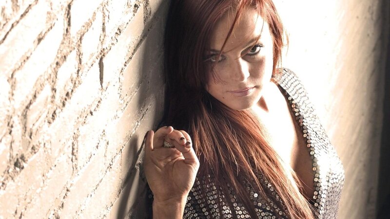 woman in sequined top against brick wall