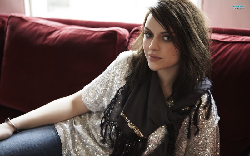 woman in sequined top on red couch