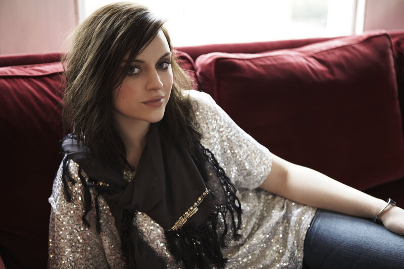 woman in sequined top on red couch