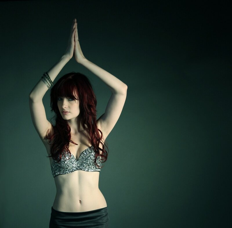 woman in sequined top with hands raised