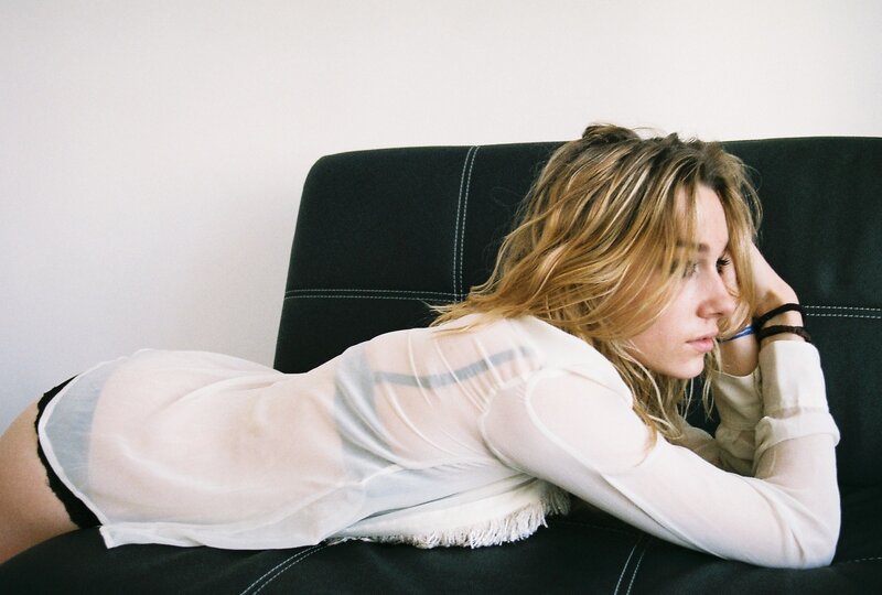 woman in sheer top lying on couch