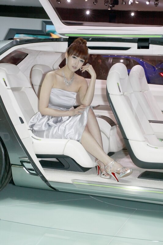 Woman in silver dress inside concept car