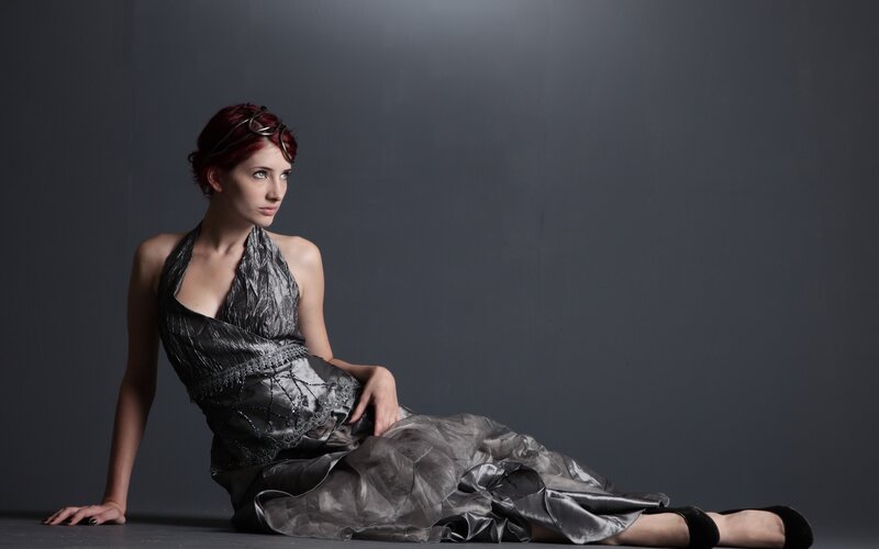 woman in silver dress sitting
