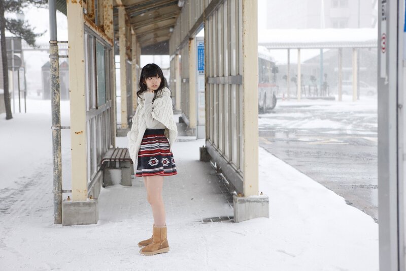 Woman in snow at bus stop