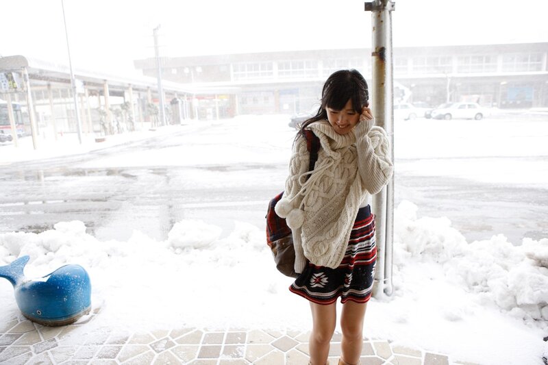 Woman in snow at bus stop