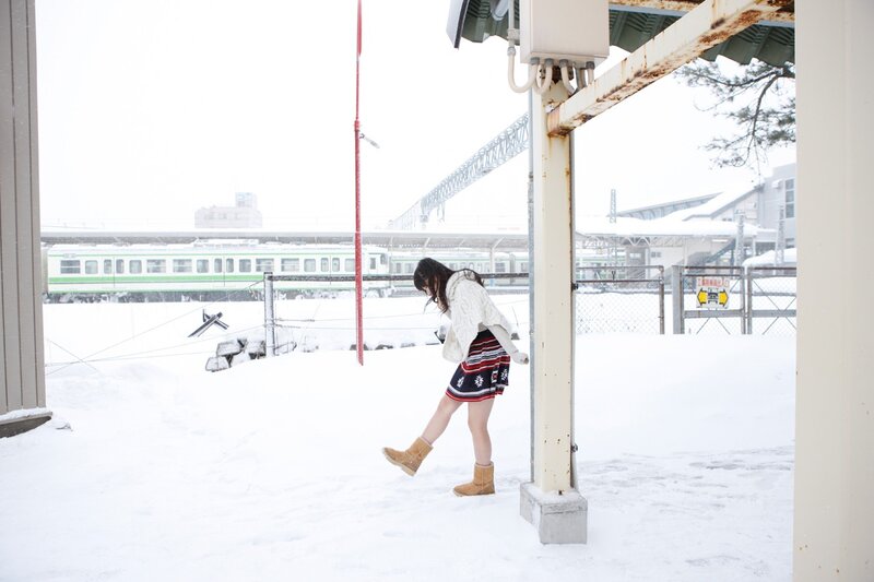 Woman in snow at train station