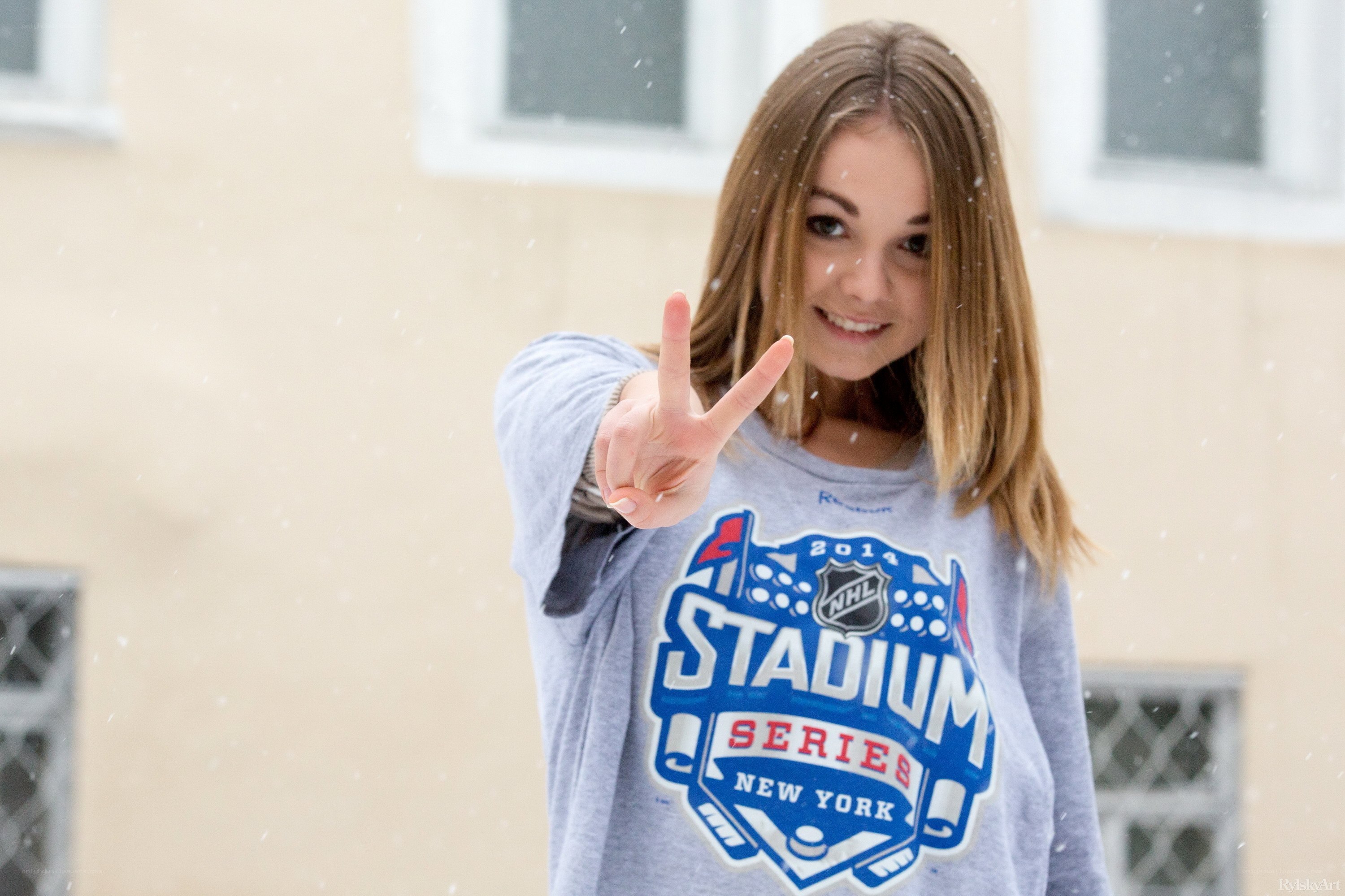 woman in snow making peace sign