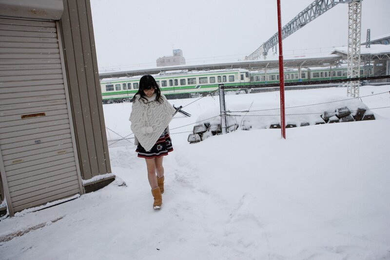Woman in snow near train station