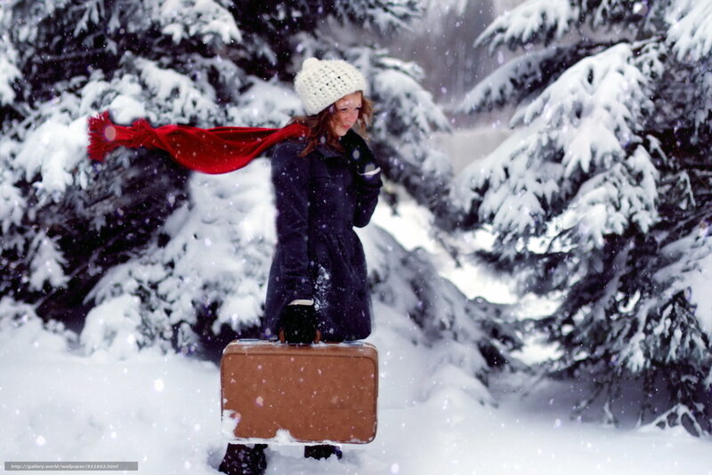 woman in snow with suitcase