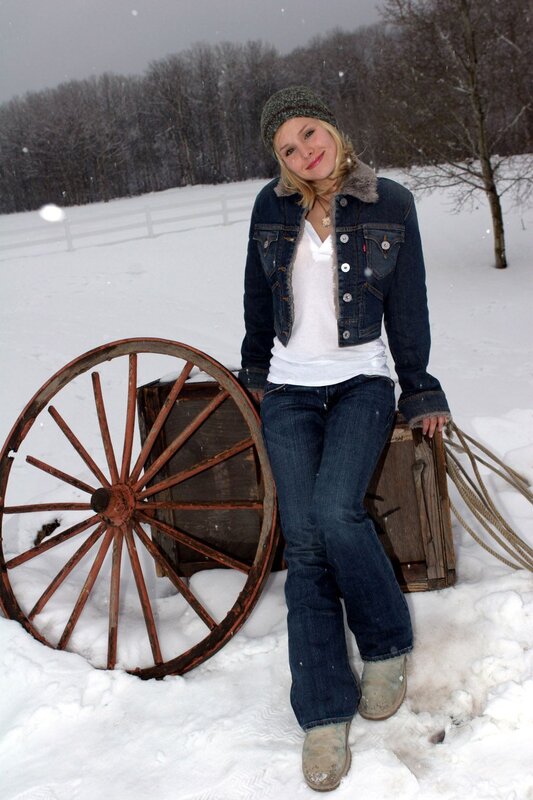 Woman in snow with wagon wheel