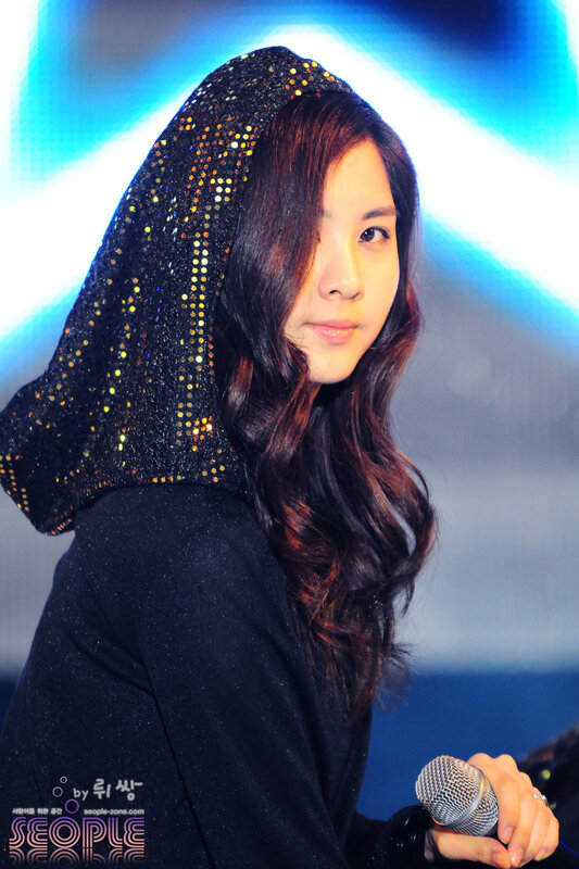 woman in sparkly hood holding microphone