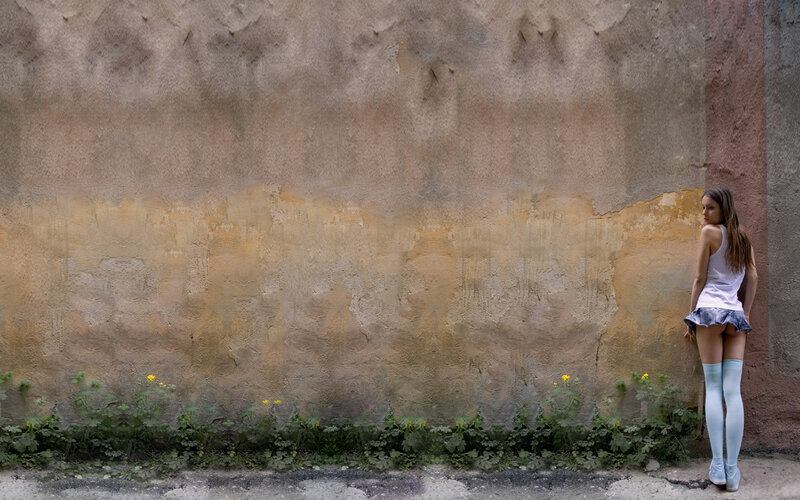 Woman in stockings by a wall