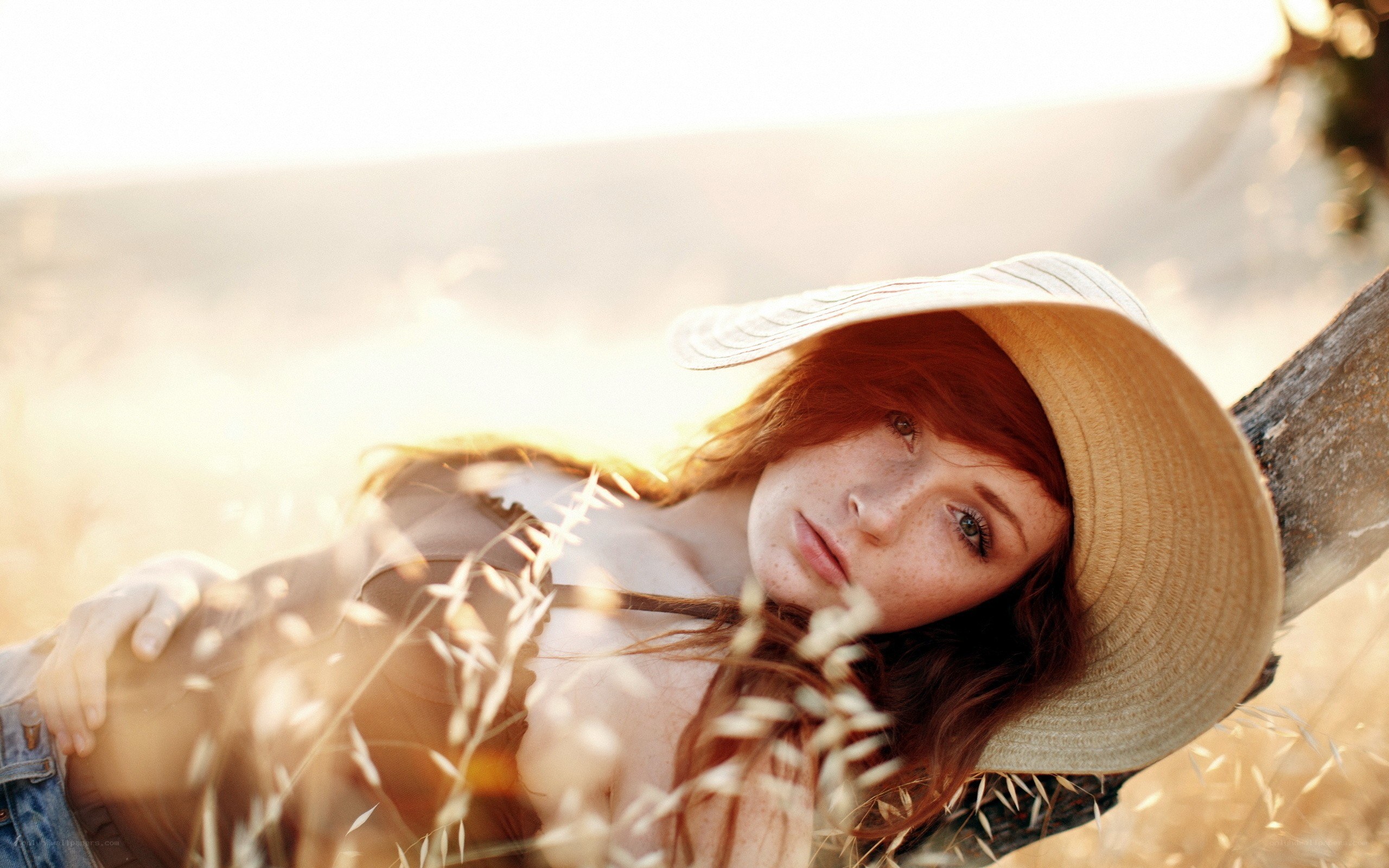 Woman in straw hat at sunset