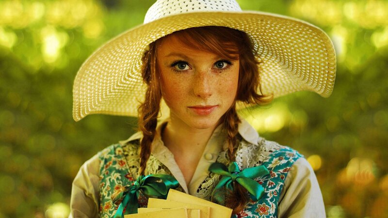 woman in straw hat holding letters
