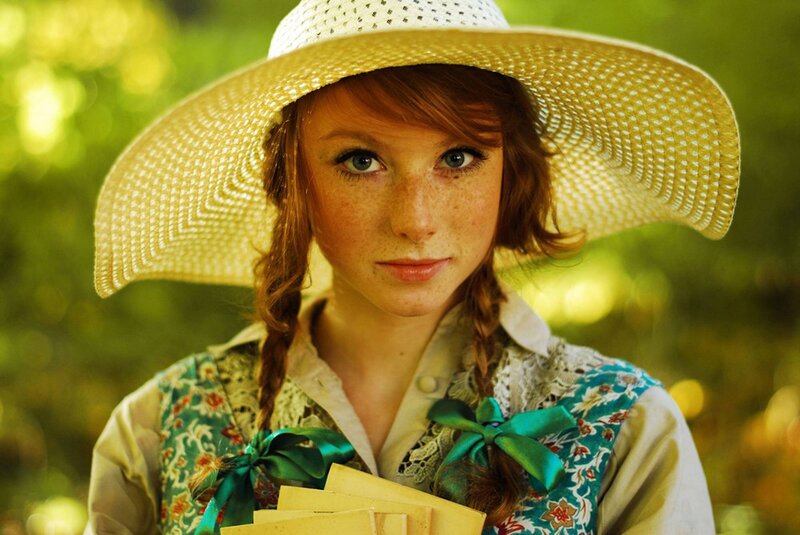 woman in straw hat holding letters