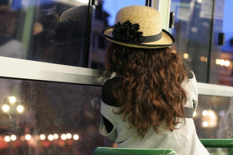 woman in straw hat looking out window