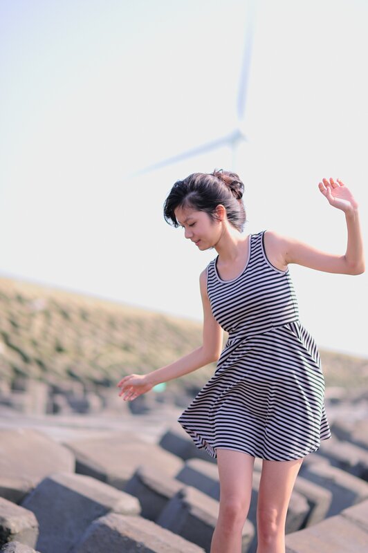 Woman in striped dress at wind farm