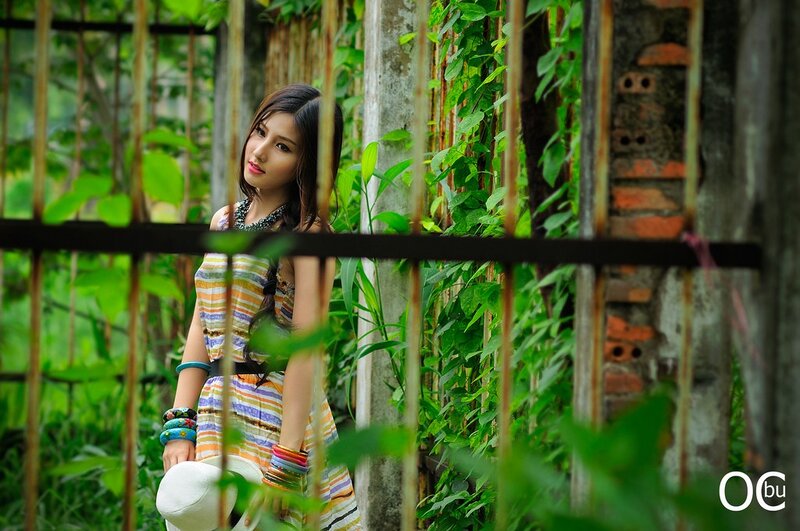 woman in striped dress behind fence