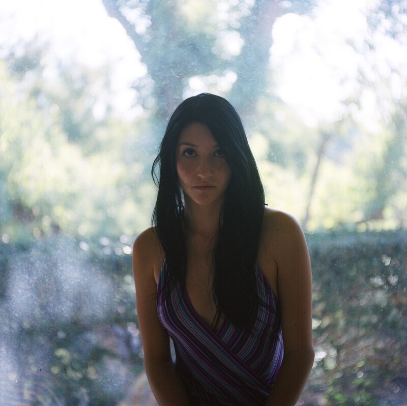 woman in striped dress by window