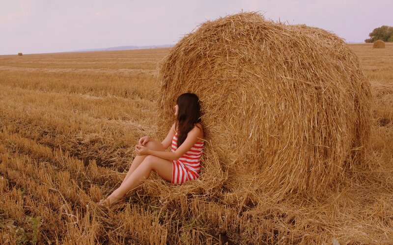 Woman in striped dress on hay bale