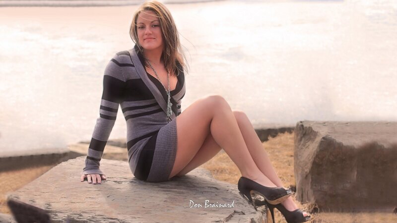woman in striped dress sitting on rock