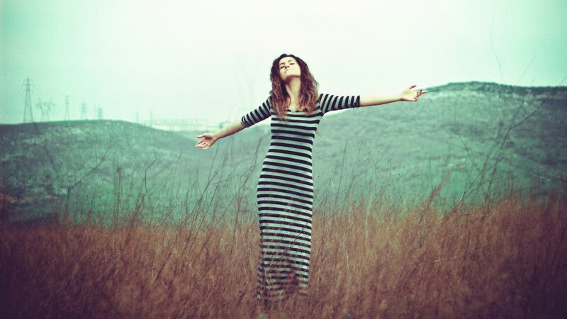 woman in striped dress with arms outstretched