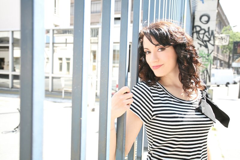 woman in striped shirt by fence