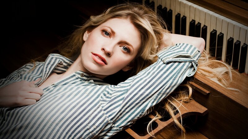 woman in striped shirt by piano