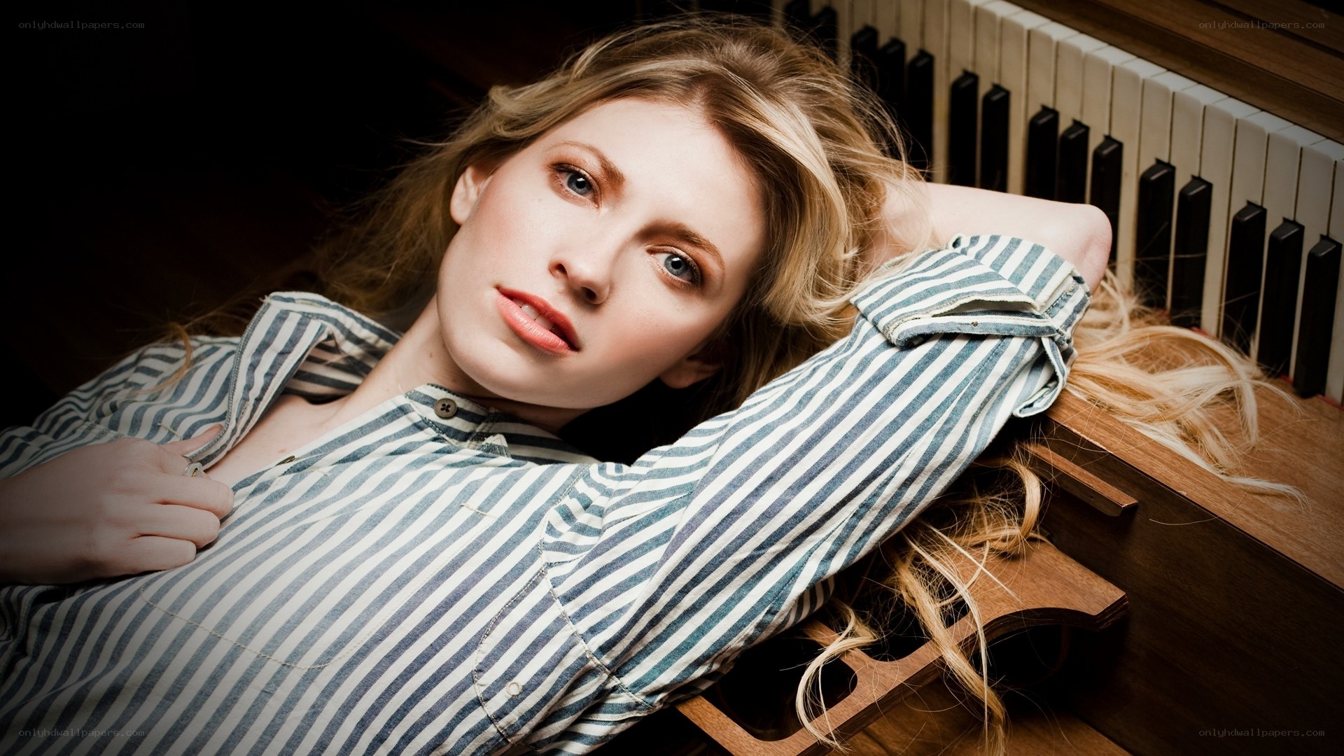 woman in striped shirt by piano