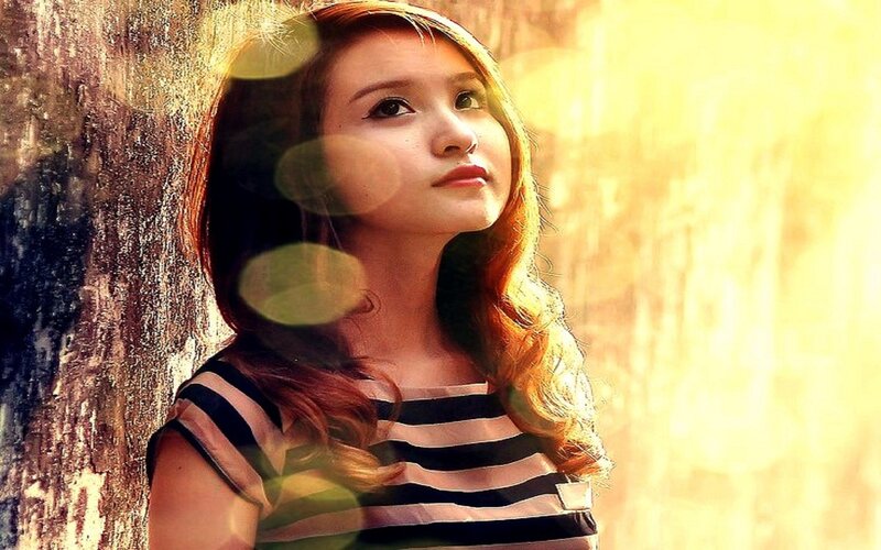 woman in striped shirt by tree