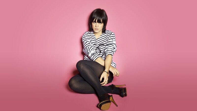 woman in striped shirt on pink background