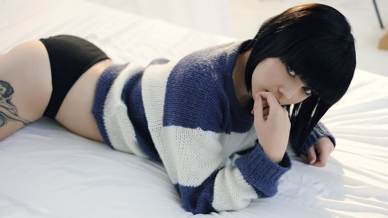 woman in striped sweater lying on bed