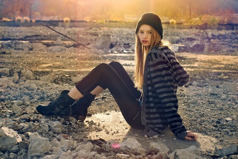 Woman in striped sweater sitting on rocks
