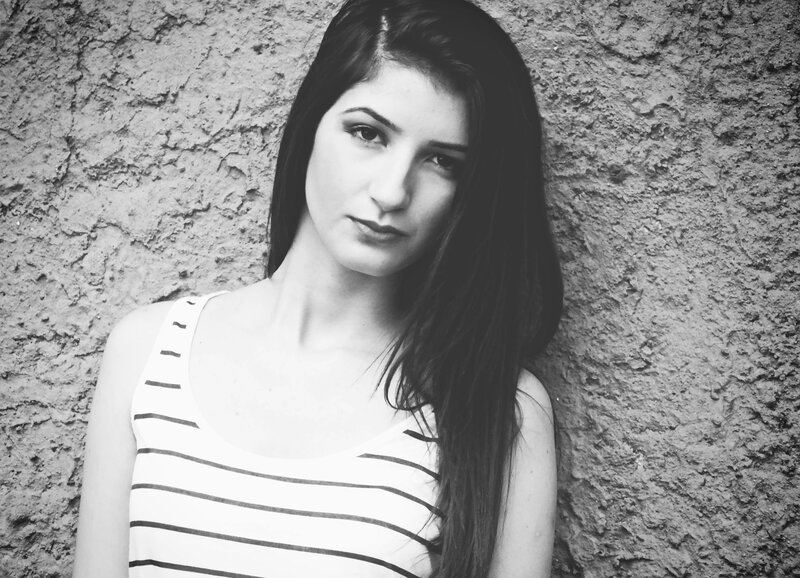 woman in striped top against wall