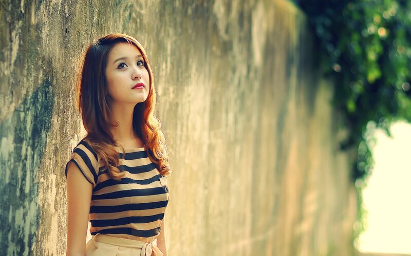 woman in striped top by wall