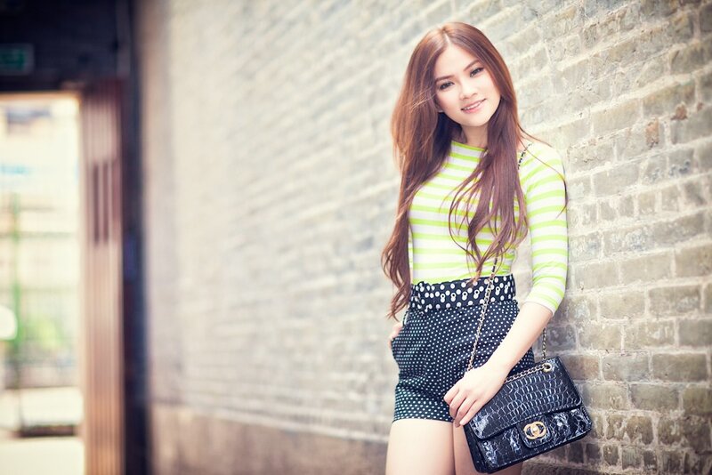 woman in striped top leaning on wall