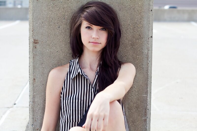 woman in striped top leaning on wall