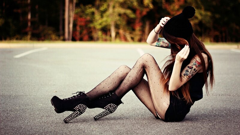 woman in studded boots sitting on road